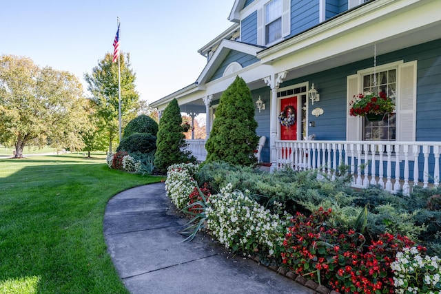 property entrance featuring a lawn and a porch