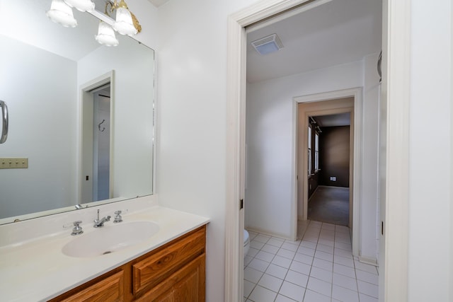 bathroom with vanity, tile patterned floors, toilet, and an inviting chandelier