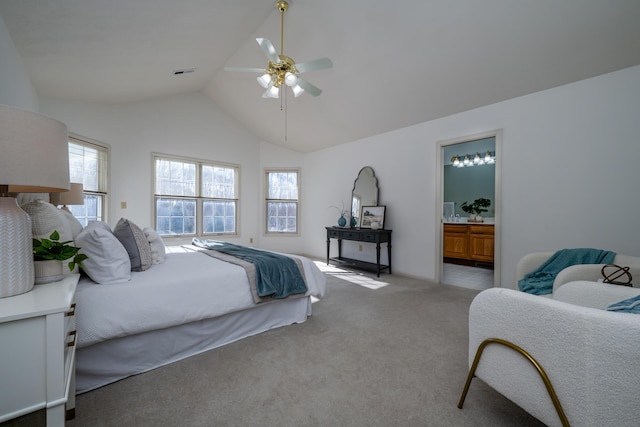 bedroom with ensuite bath, vaulted ceiling, light colored carpet, and ceiling fan