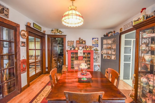 dining area with light wood-type flooring and french doors