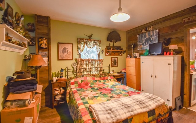 bedroom with wooden walls and dark hardwood / wood-style floors