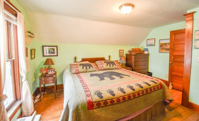 bedroom with hardwood / wood-style floors and vaulted ceiling