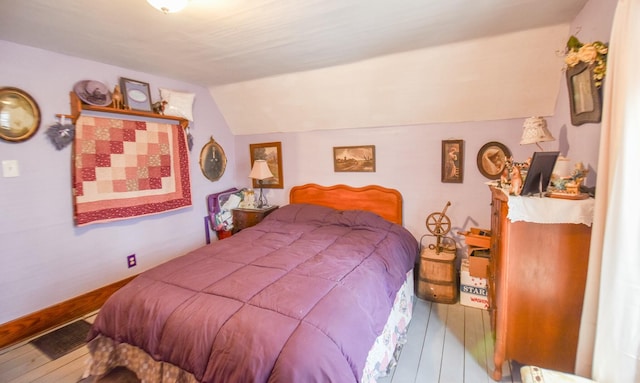 bedroom featuring lofted ceiling and hardwood / wood-style flooring