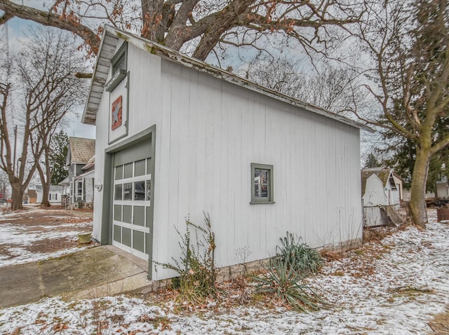 snow covered property with an outbuilding and a garage