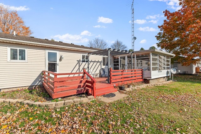 back of house featuring a sunroom, a deck, and a yard