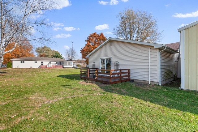 rear view of property with a deck and a yard