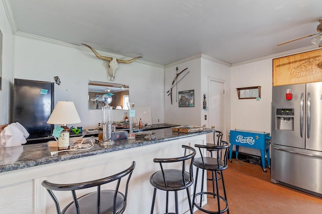 kitchen featuring stainless steel fridge with ice dispenser, ceiling fan, crown molding, and a breakfast bar area