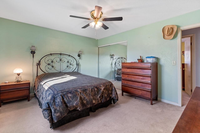 bedroom featuring ceiling fan, a closet, and light colored carpet