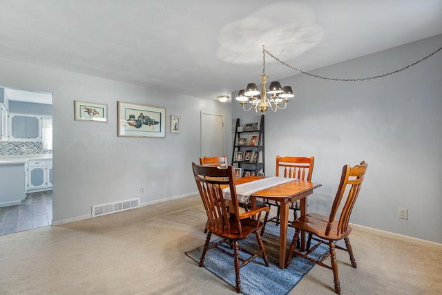 dining room featuring light carpet and an inviting chandelier