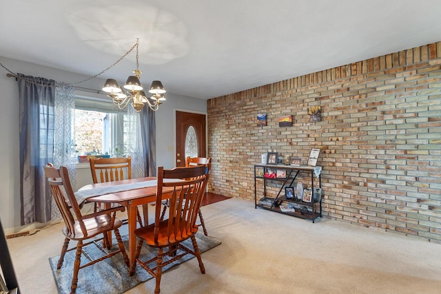 carpeted dining room featuring brick wall and an inviting chandelier