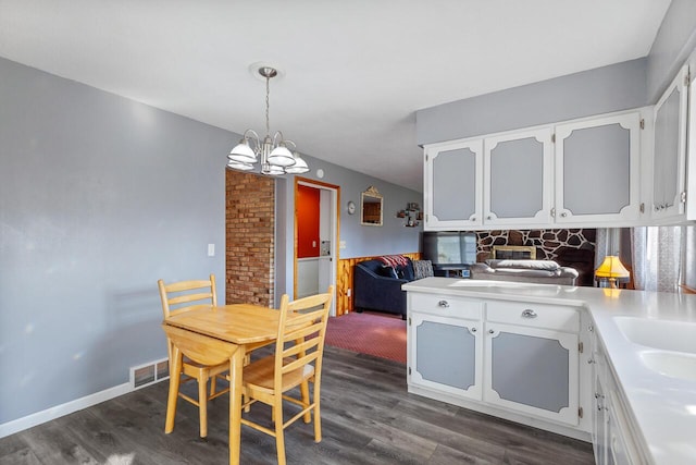 kitchen with white cabinetry, dark hardwood / wood-style flooring, decorative light fixtures, and a notable chandelier