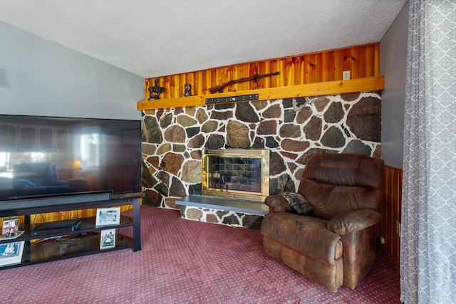 carpeted living room with a fireplace, wood walls, and a textured ceiling