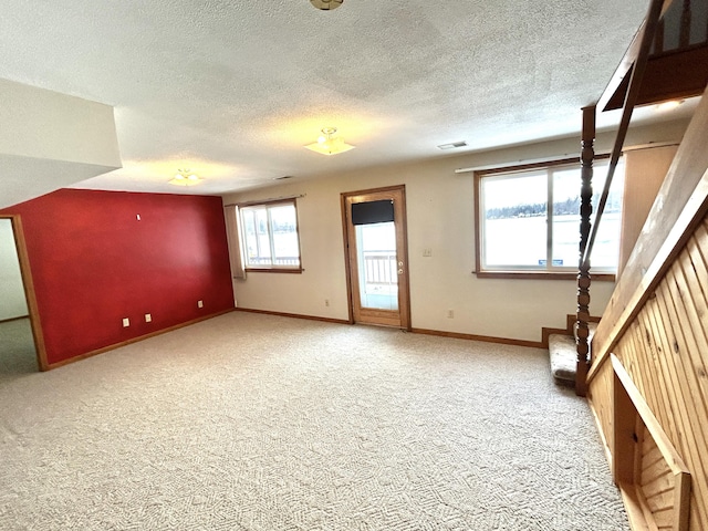 additional living space featuring a textured ceiling and carpet