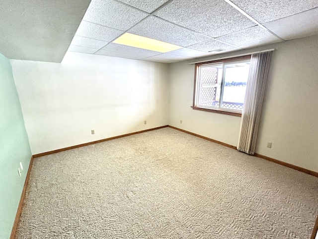 carpeted spare room with a paneled ceiling