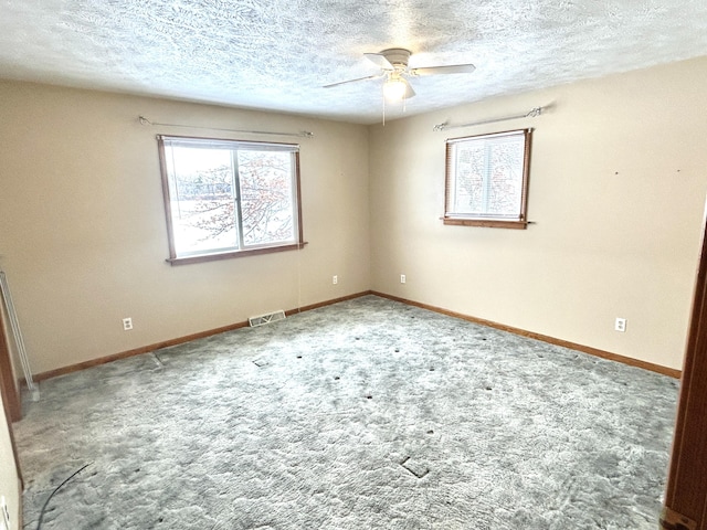 unfurnished room featuring ceiling fan and a textured ceiling