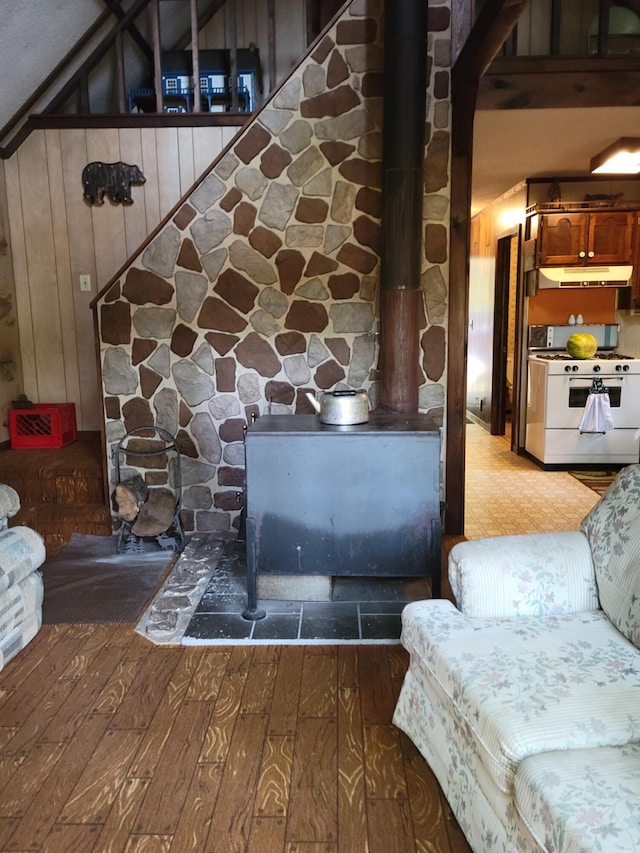 interior details with wood-type flooring, wooden walls, and white gas stove