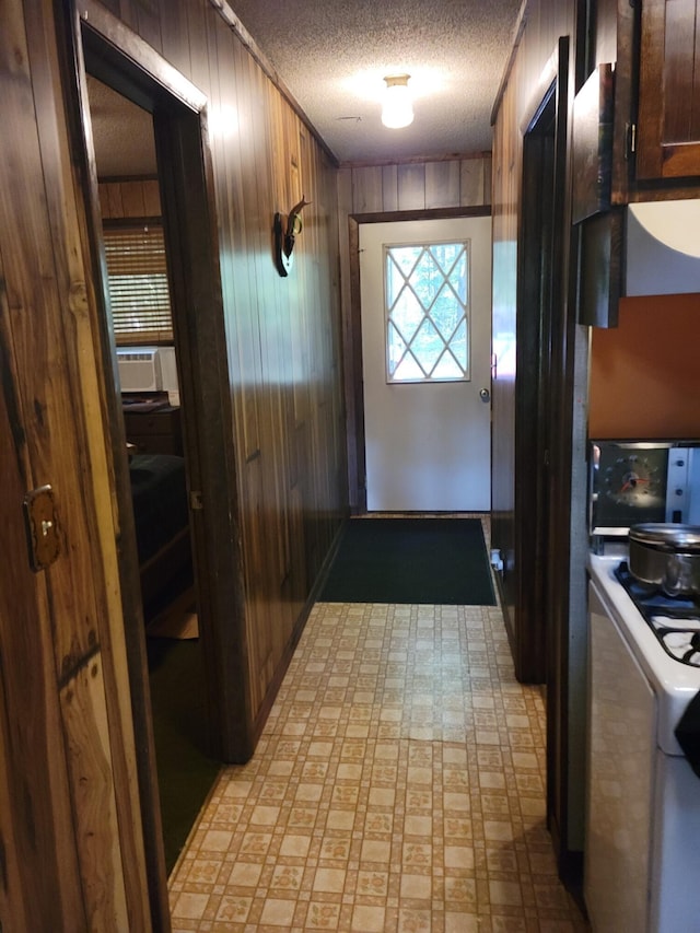 entryway with wooden walls and a textured ceiling