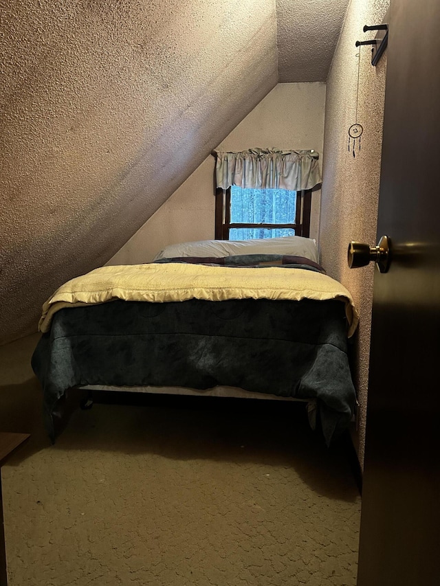 bedroom with carpet, a textured ceiling, and vaulted ceiling