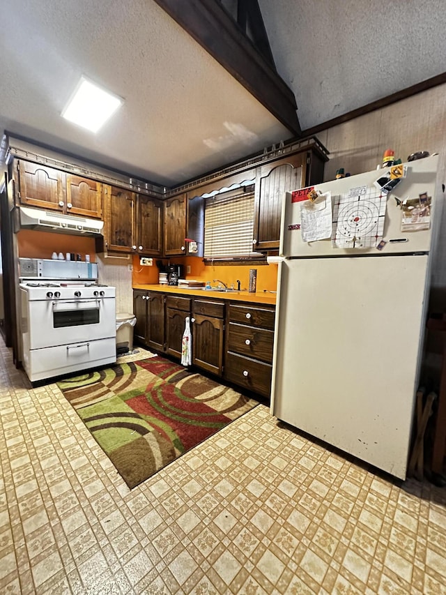 kitchen featuring a textured ceiling, dark brown cabinets, white appliances, and sink