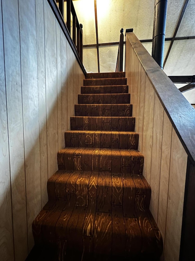 stairs featuring wood walls