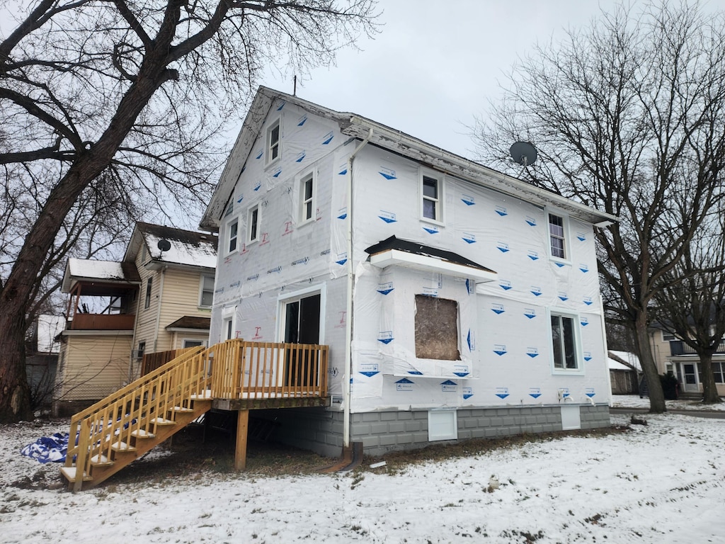 view of snow covered back of property