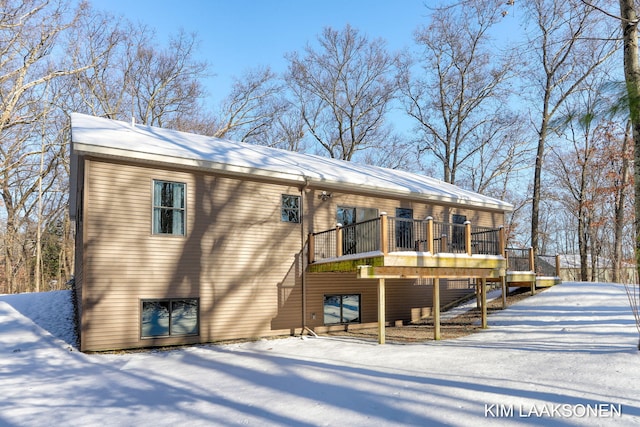 snow covered house with a deck