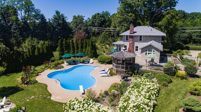 view of swimming pool featuring a gazebo, a wooden deck, and a diving board