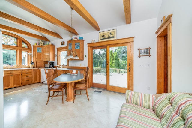 dining space featuring vaulted ceiling with beams