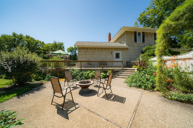 view of patio / terrace featuring a deck and an outdoor fire pit