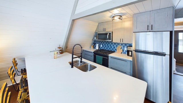 kitchen featuring tasteful backsplash, gray cabinets, sink, and appliances with stainless steel finishes