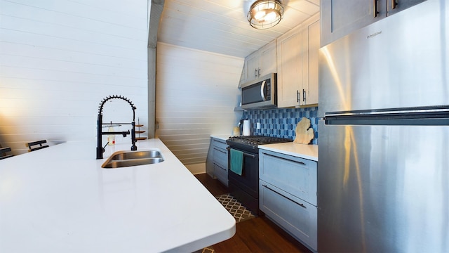 kitchen with sink, decorative backsplash, gray cabinets, dark hardwood / wood-style floors, and stainless steel appliances