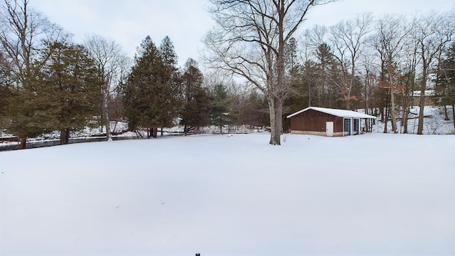 yard layered in snow featuring an outdoor structure