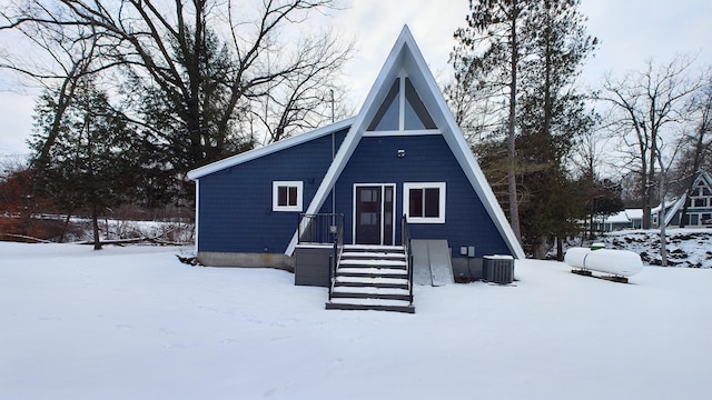 snow covered back of property with central AC