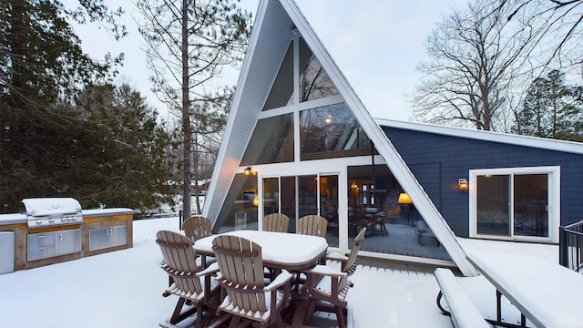 snow covered property featuring a sunroom and area for grilling