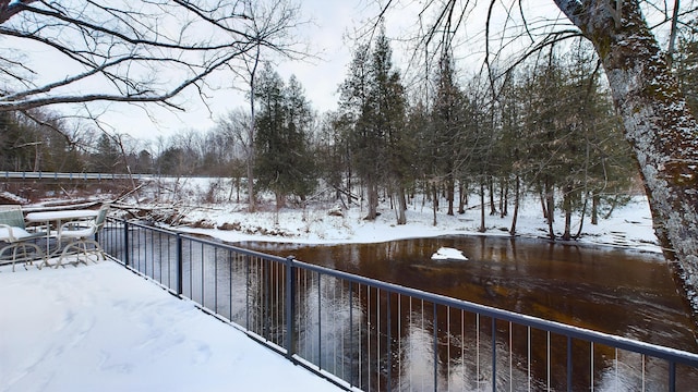 yard layered in snow featuring a water view