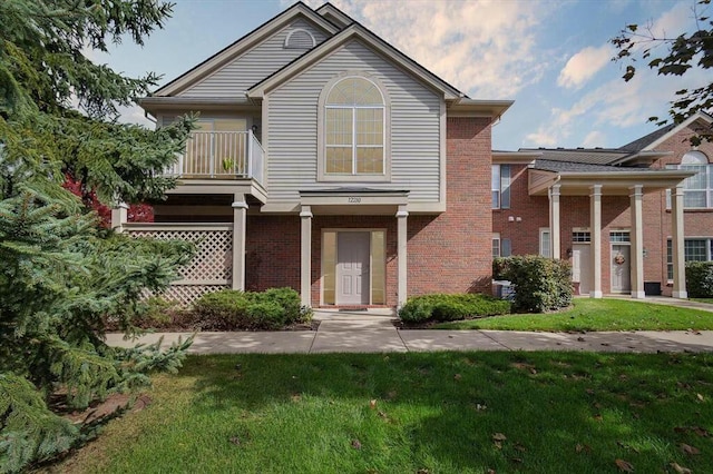 view of front of home featuring a balcony and a front yard