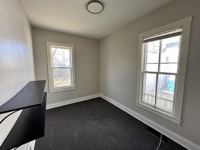 empty room featuring dark carpet