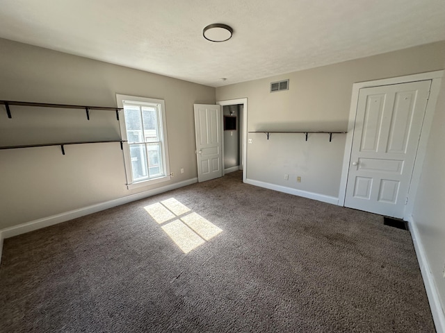 unfurnished bedroom with dark carpet