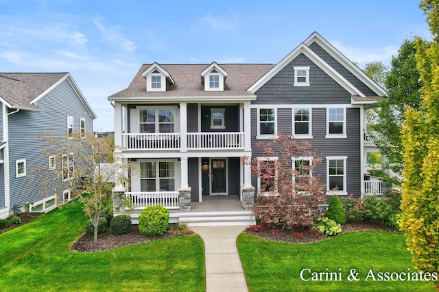 view of front facade featuring a front yard, covered porch, and a balcony