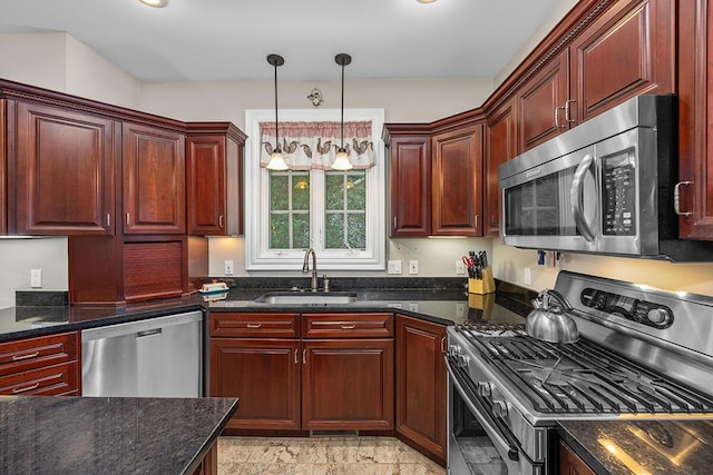 kitchen with pendant lighting, sink, stainless steel appliances, and dark stone counters