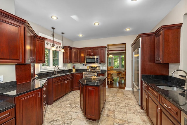 kitchen with a center island, sink, stainless steel appliances, and hanging light fixtures