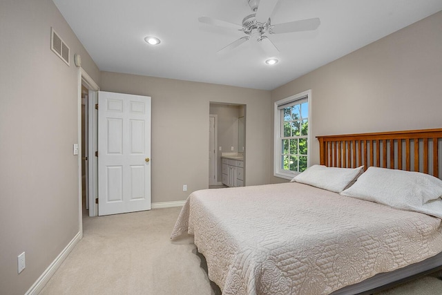 bedroom featuring connected bathroom, ceiling fan, and light colored carpet