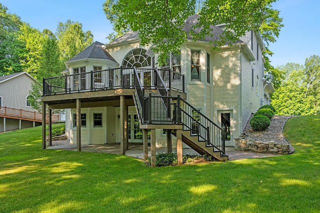 rear view of house featuring a lawn, a patio area, and a deck