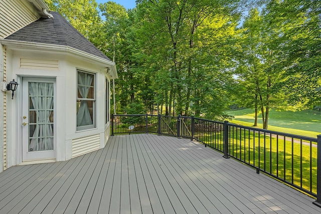 wooden deck featuring a lawn