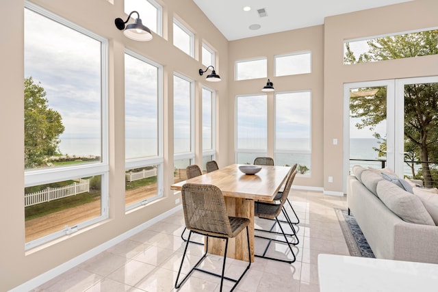 sunroom featuring a water view