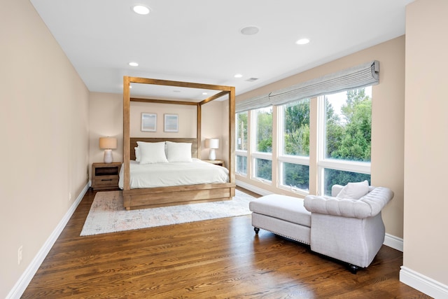 bedroom with beamed ceiling and dark hardwood / wood-style floors