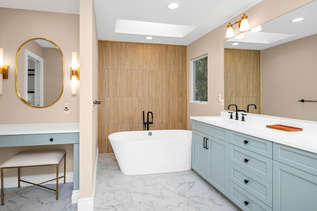 bathroom featuring a skylight, vanity, and a bath