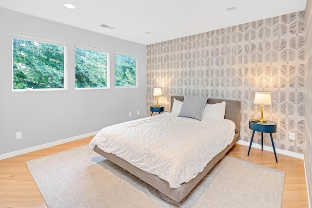 bedroom with multiple windows and hardwood / wood-style flooring