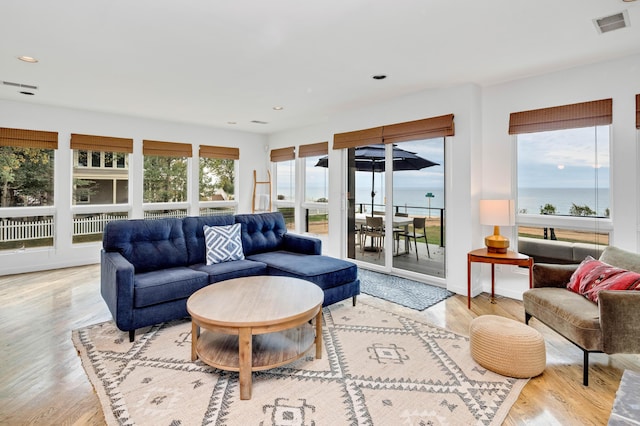 living room with a water view and light wood-type flooring