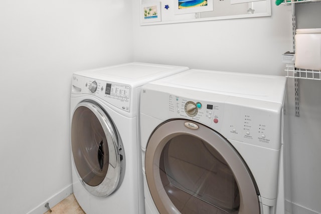 clothes washing area featuring light tile patterned floors and washer and clothes dryer